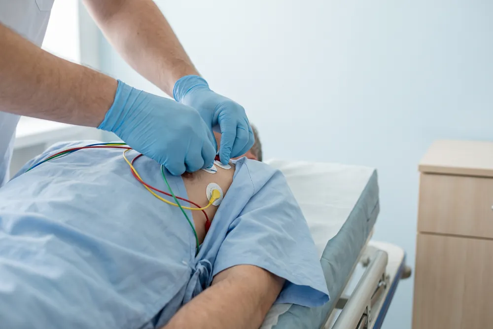 Acil serviste hastaya EKG çekilirken monitörde kalp ritmi eğrisi.
